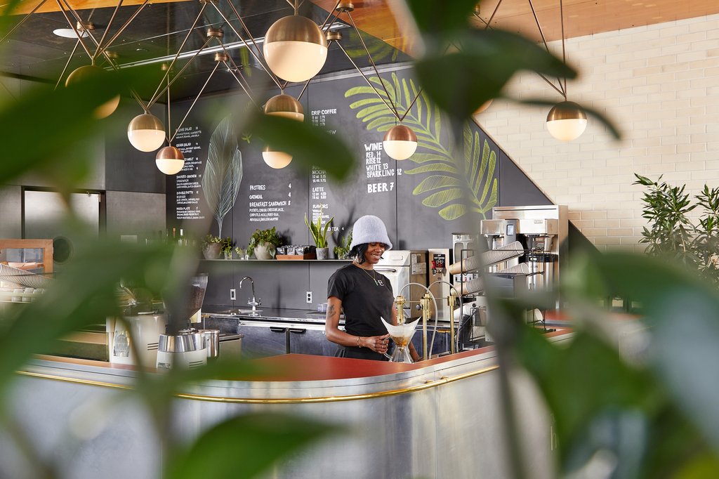 A girl at coffee bar making coffee at The Emily Hotel